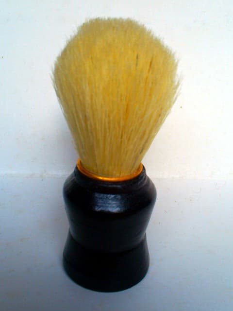 A traditional shaving brush resting in a lather bowl